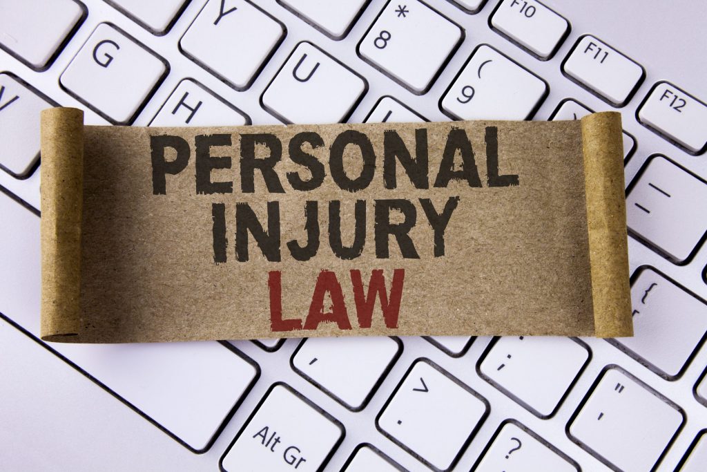 Conceptual hand writing showing Personal Injury Law. Business photo showcasing guarantee your rights in case of hazards or risks written Folded Cardboard Paper Piece placed Keyboard.